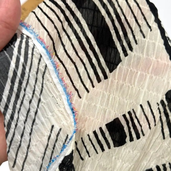 Tissu polyester gaufré rayures abstraites noires sur fond crème Tissu polyester gaufré rayures abstraites noires sur fond crème