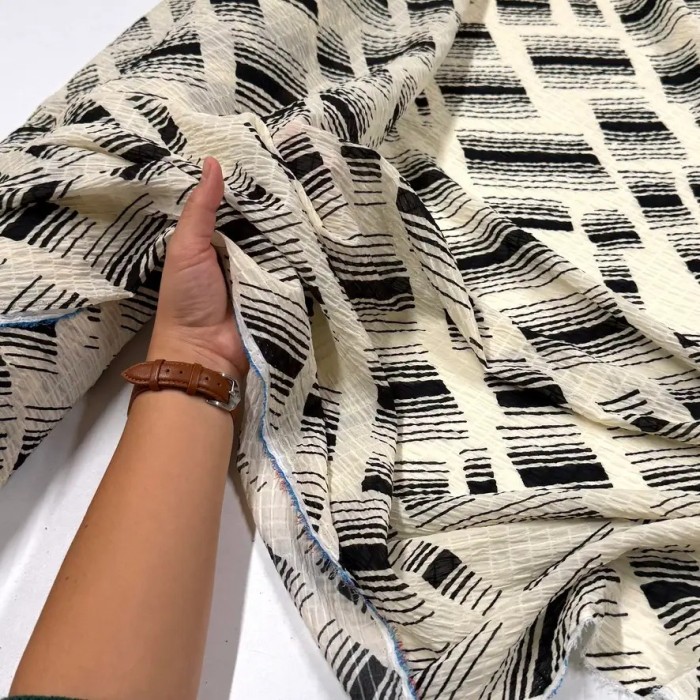 Tissu polyester gaufré rayures abstraites noires sur fond crème