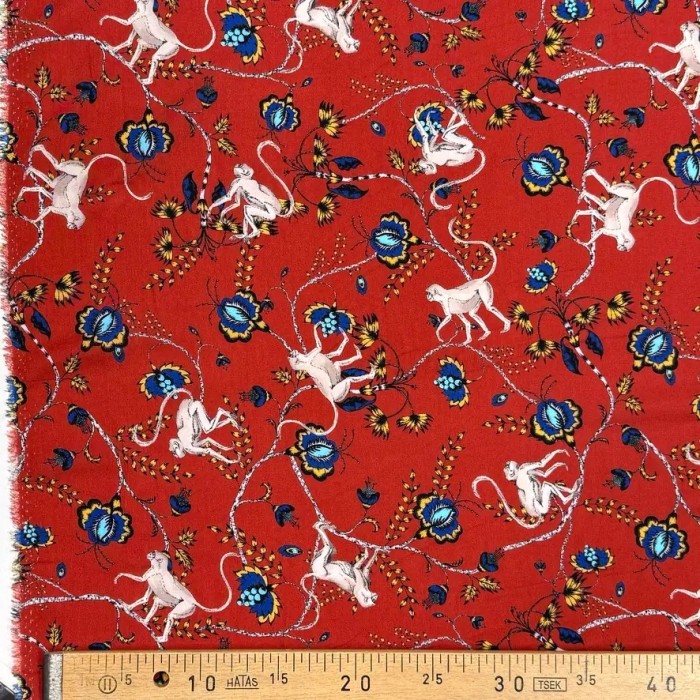 Tissu viscose singes et fleurs exotiques sur fond rouge