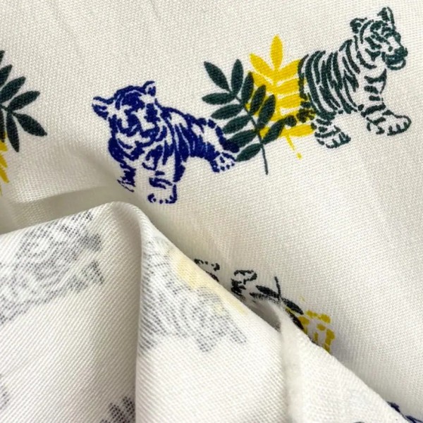 Tissu coton élasthanne tigres et feuillage sur fond blanc Tissu coton élasthanne tigres et feuillage sur fond blanc