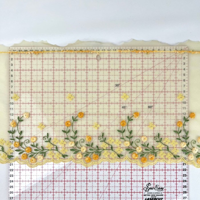 Dentelle fleurs oranges verts sur tulle jaune 21cm