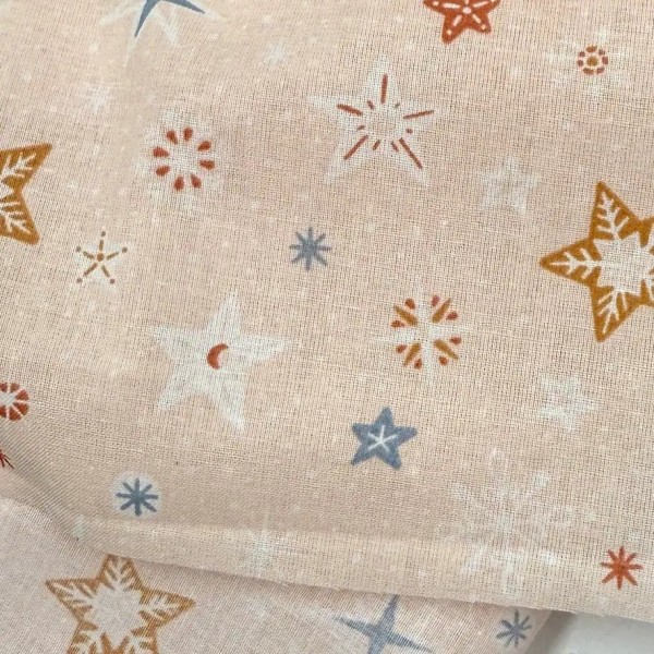 Tissu Coton imprimé étoiles et flocons abricot Tissu Coton imprimé étoiles et flocons abricot